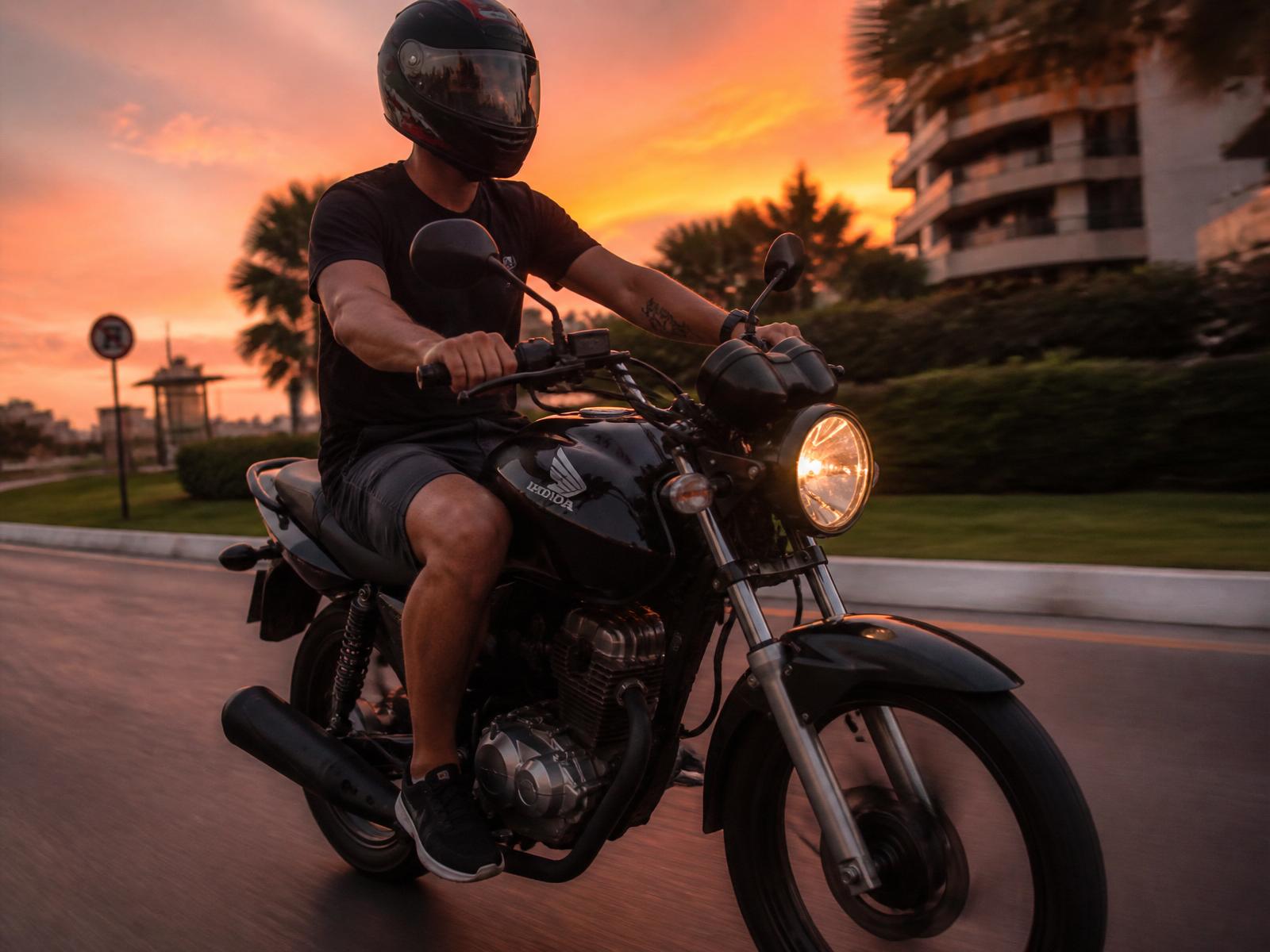 Motociclista em uma moto Honda ao entardecer